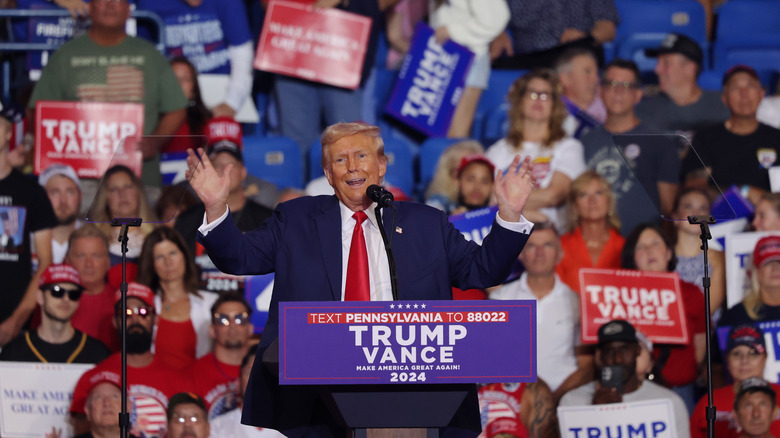 Trump speaking at rally arms out