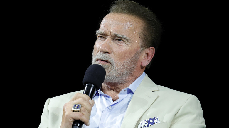 Arnold Schwarzenegger speaking into microphone