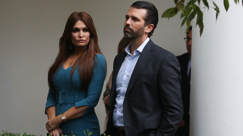 Kimberly Guilfoyle teal dress with Donald Trump Jr. looking serious