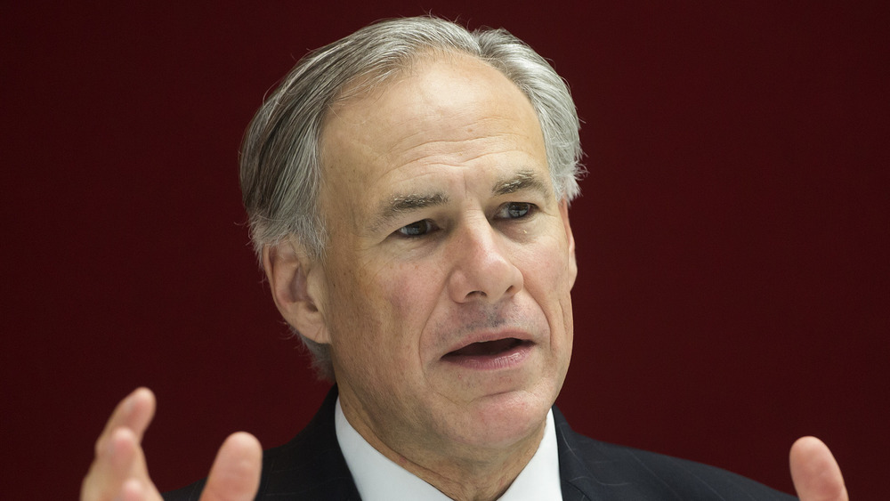 Greg Abbott with serious expression and hands up