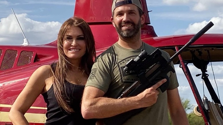 Kimberly Guilfoyle and Donald Trump Jr. pose side by side, Trump holding gun