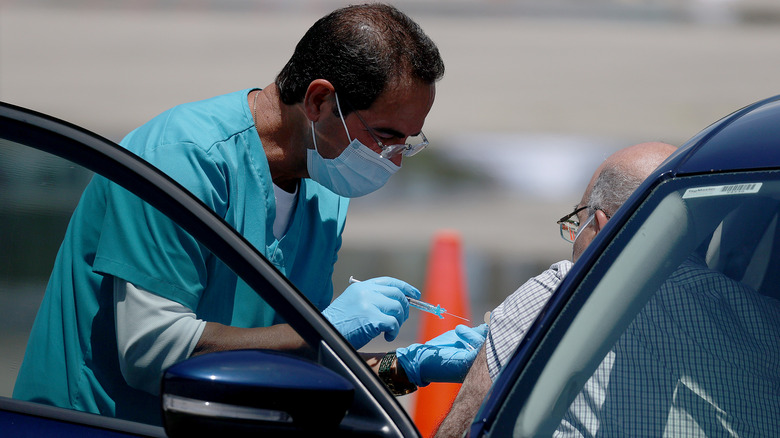 Medical worker vaccinating against COVID