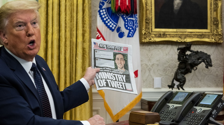 Then-President Donald Trump holding up a copy of The New York Post