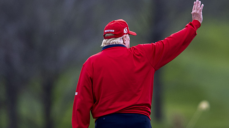 Donald Trump waving on a golf course