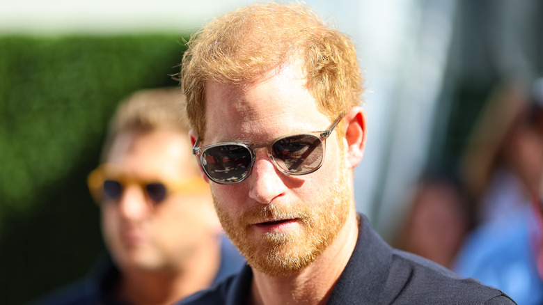 Prince Harry wearing sunglasses while walking