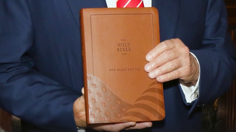 Donald Trump's hands holding God Bless the USA Bible