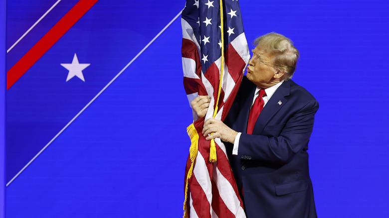 Donald Trump hugging and kissing American flag