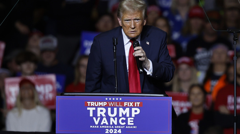 Donald Trump holding microphone at podium 11/1/24