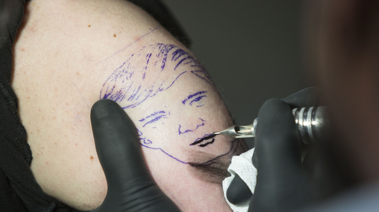 Tattooing someone with Donald Trump's face