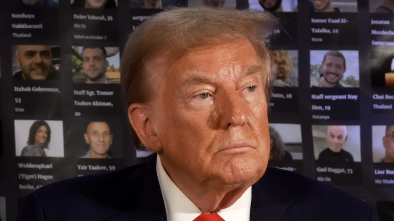 Donald Trump with closed thin lips, a serious look, and a bad tan