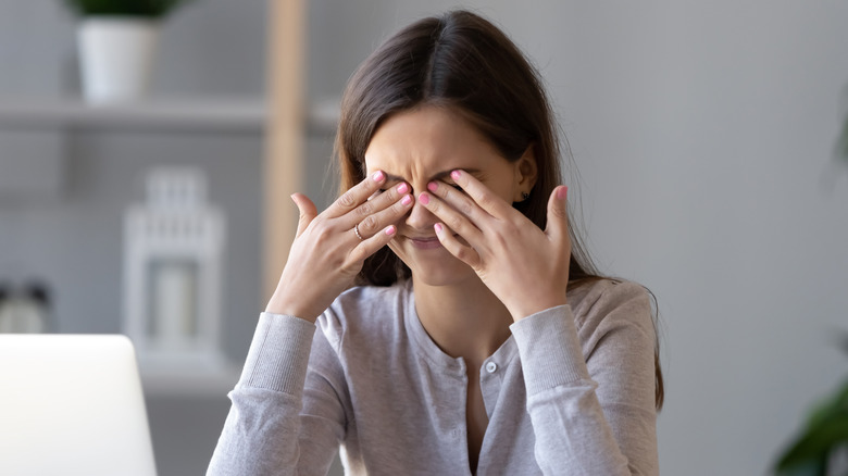 woman rubbing her eyes