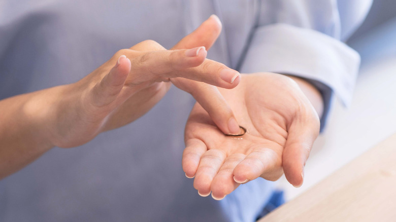 woman rubbing contacts with finger