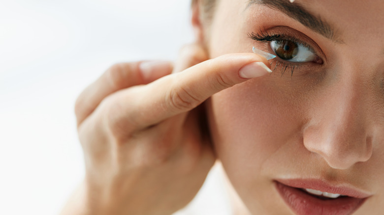 woman inserting a contact lens