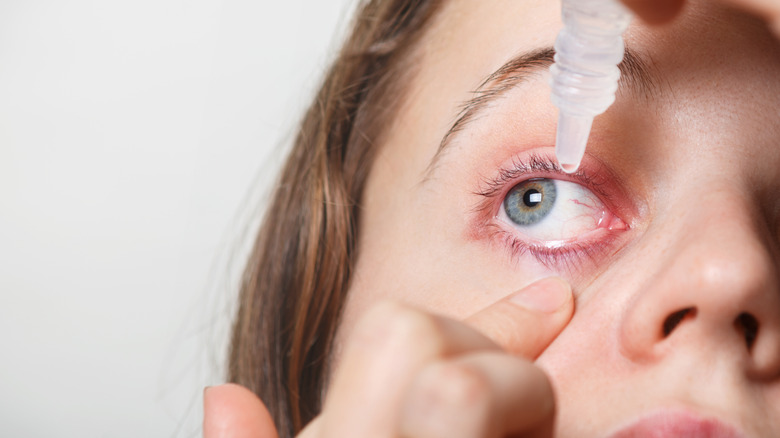 woman using eye drops 