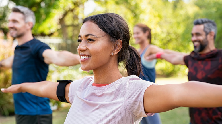 smiling woman doing yoga outside