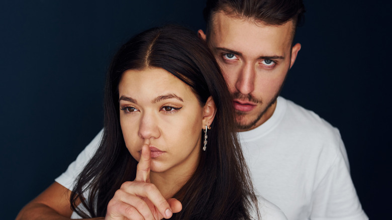 Aggressive man silencing his girlfriend 