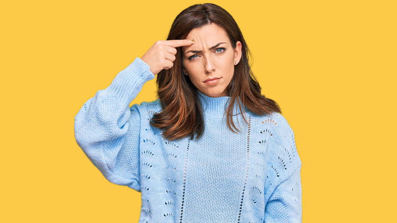 A woman pointing at her pimple