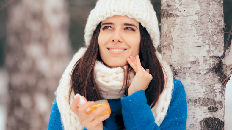 Woman applying sunscreen in winter