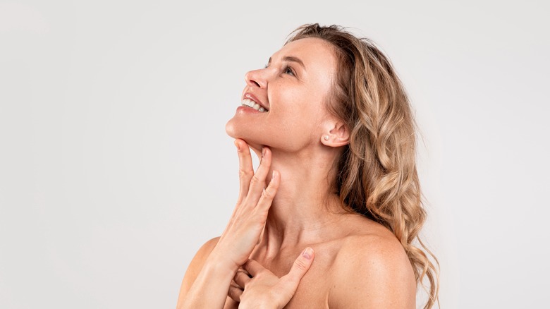 Woman applying product to clean face and neck