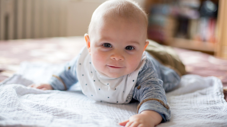 smiling baby crawling on blanket