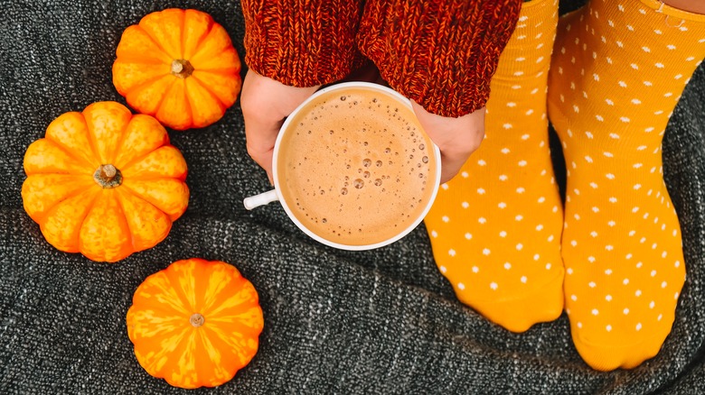 pumpkins and hands holding coffee