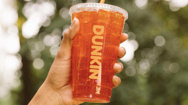 hand holding Dunkin' iced drink