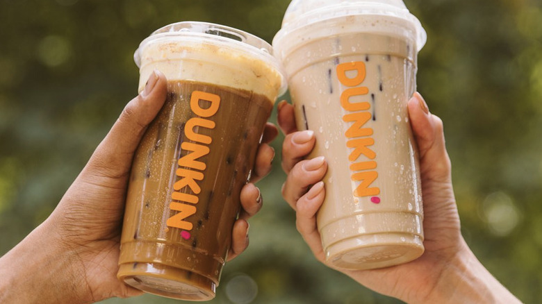 two hands toasting with iced Dunkin' drinks