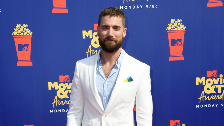 Dustin Milligan in white jacket