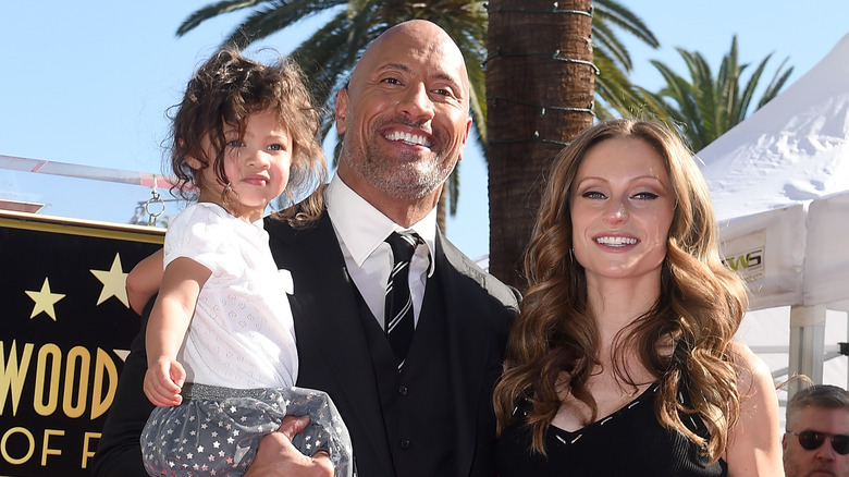 Dwayne Johnson and Lauren Hashian smiling with their daughter