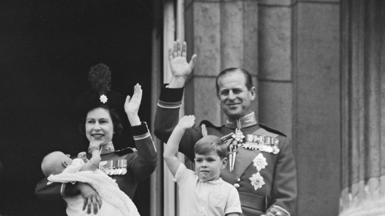 Queen Elizabeth II holding Prince Edward and waving