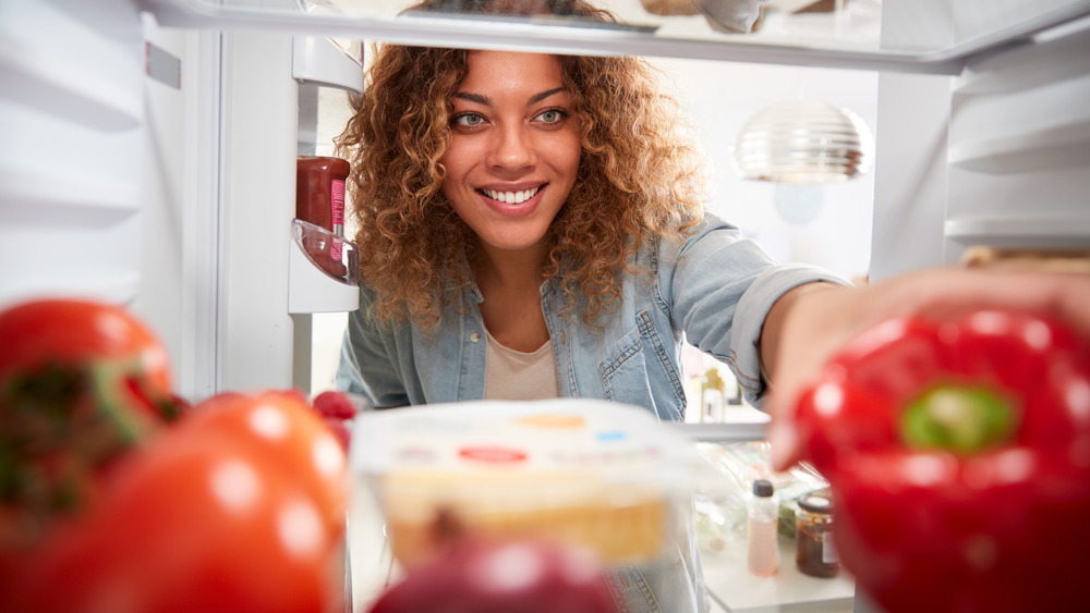 Woman reaching for bell pepper 