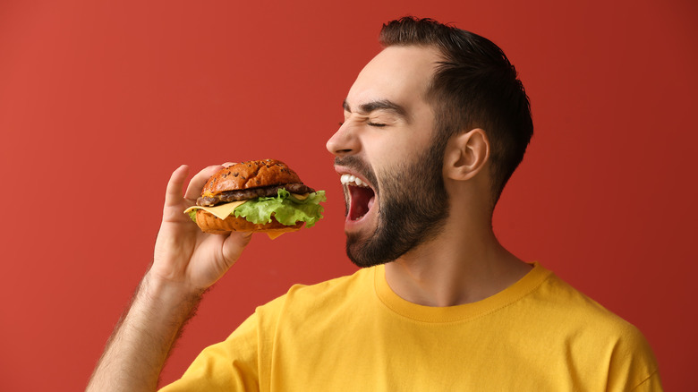 man biting into burger