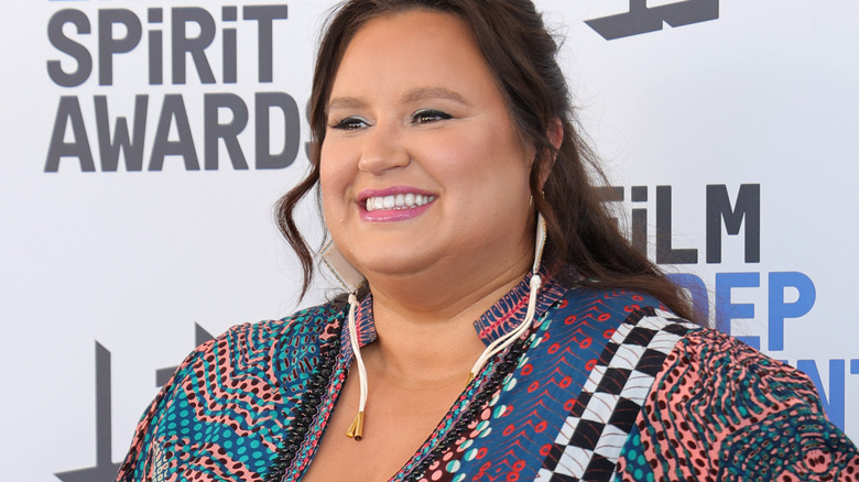 Jana Schmieding smiling on a red carpet in bright colors