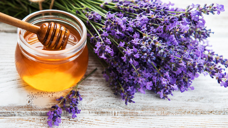 A jar of honey next to lavender