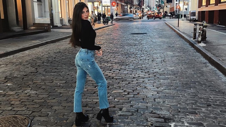 Woman wearing straight leg jeans and heeled boots