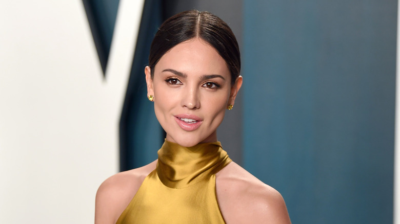 Eiza González smiling in gold dress