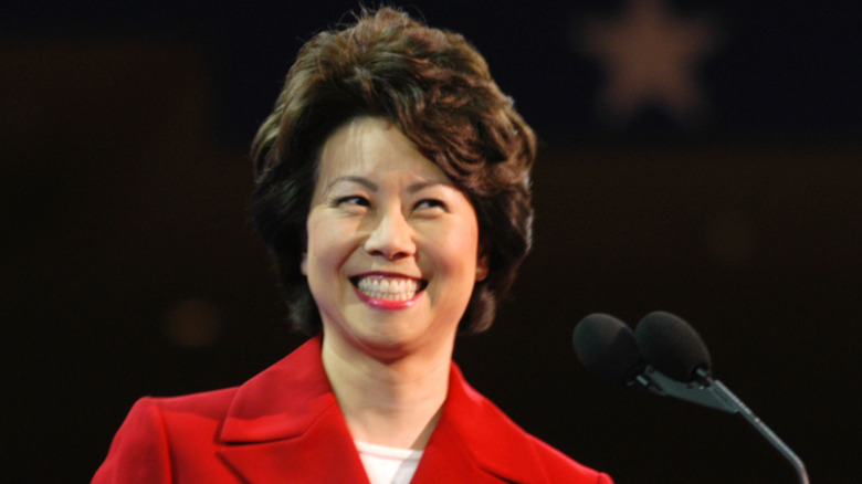 Elaine Chao smiling next to microphone