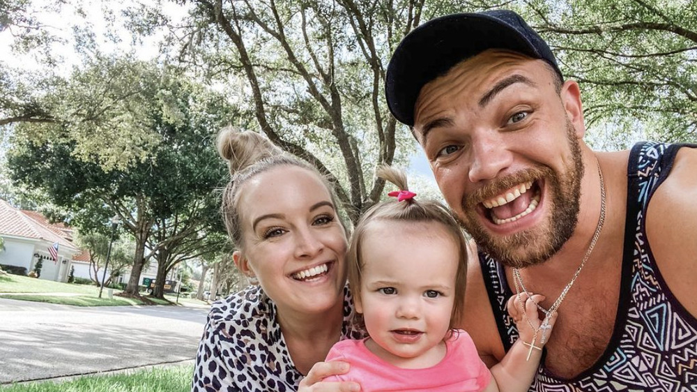 Elizabeth and Andrei grinning with their daughter