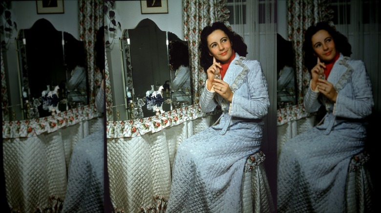 Elizabeth Taylor applying perfume