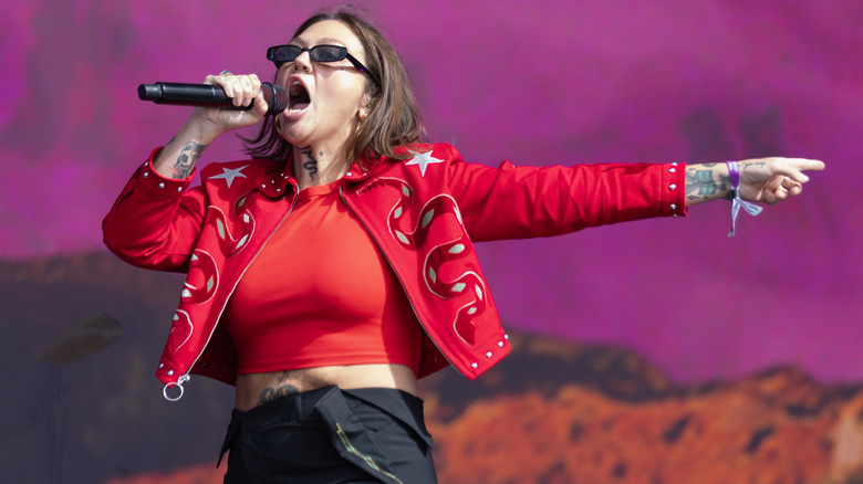 Elle King singing into microphone wearing red jacket