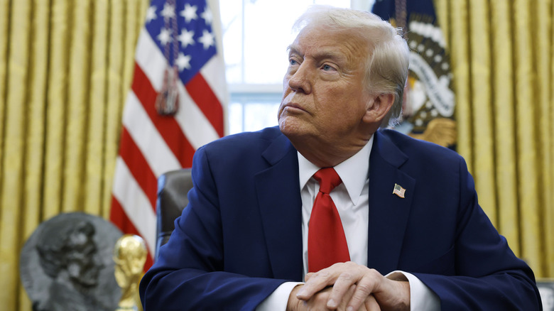 Donald Trump sitting at desk hands folded