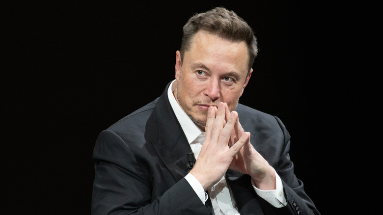 Elon Musk puts his hands together in thought