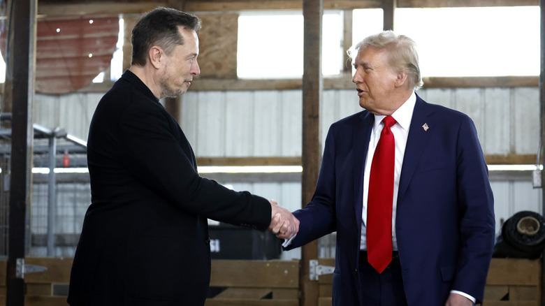 Elon Musk and Donald Trump shaking hands in suits