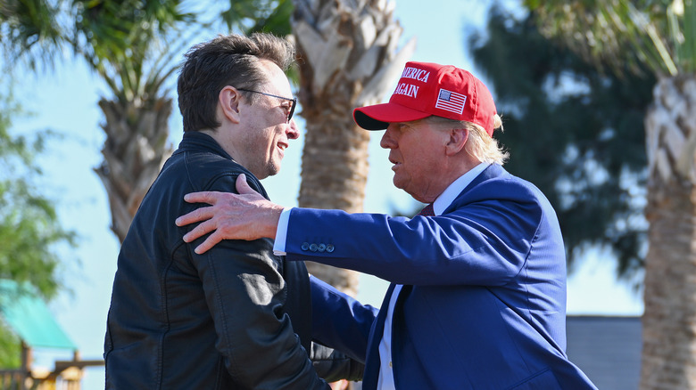 Donald Trump talking to Elon Musk with his hand on his shoulder