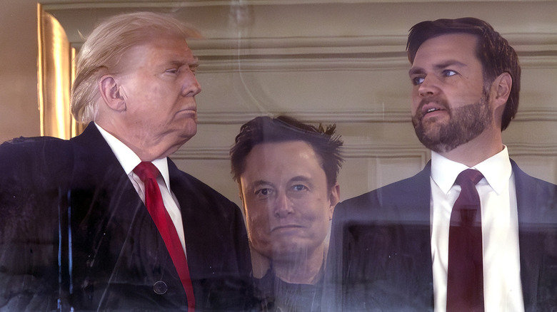 Donald Trump and JD Vance talking with Elon Musk staring in the background