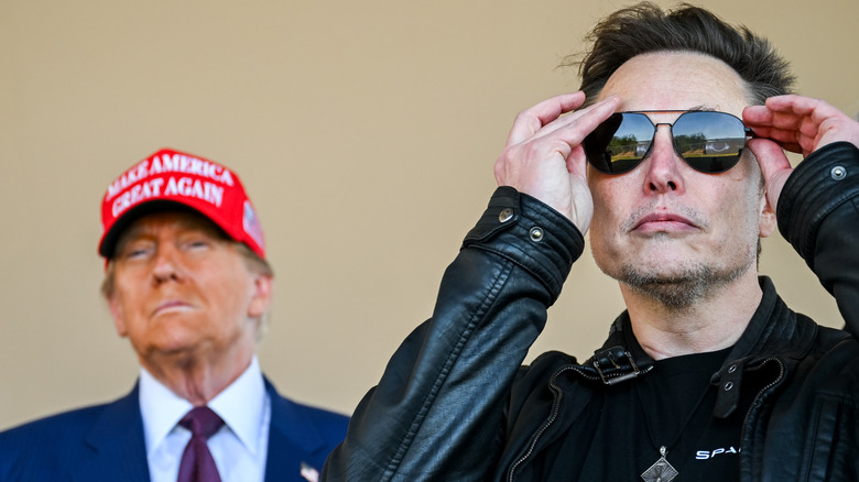 Donald Trump standing behind Elon Musk