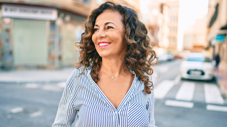 Middle aged woman in street smiling