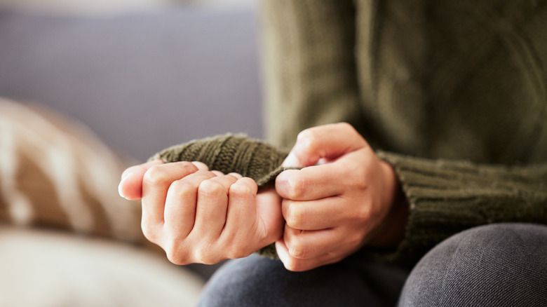 woman anxiously pulling on sleeve