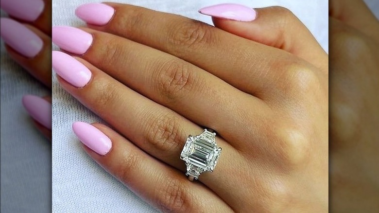 Emerald-cut engagement ring with a pink manicure