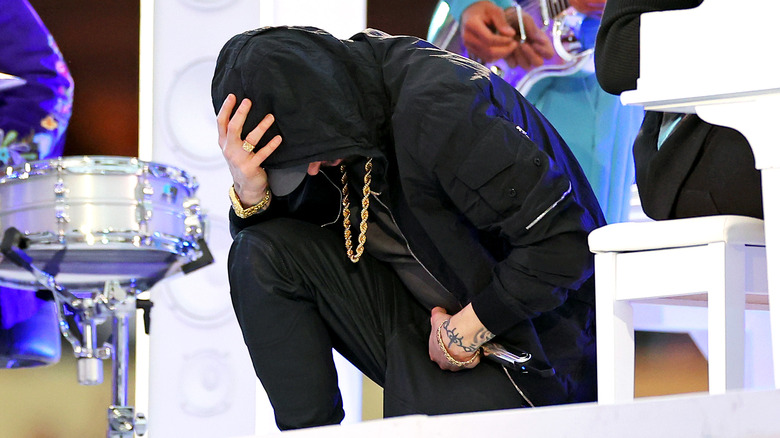 Rapper Eminem kneels after his Super Bowl LVI performance.